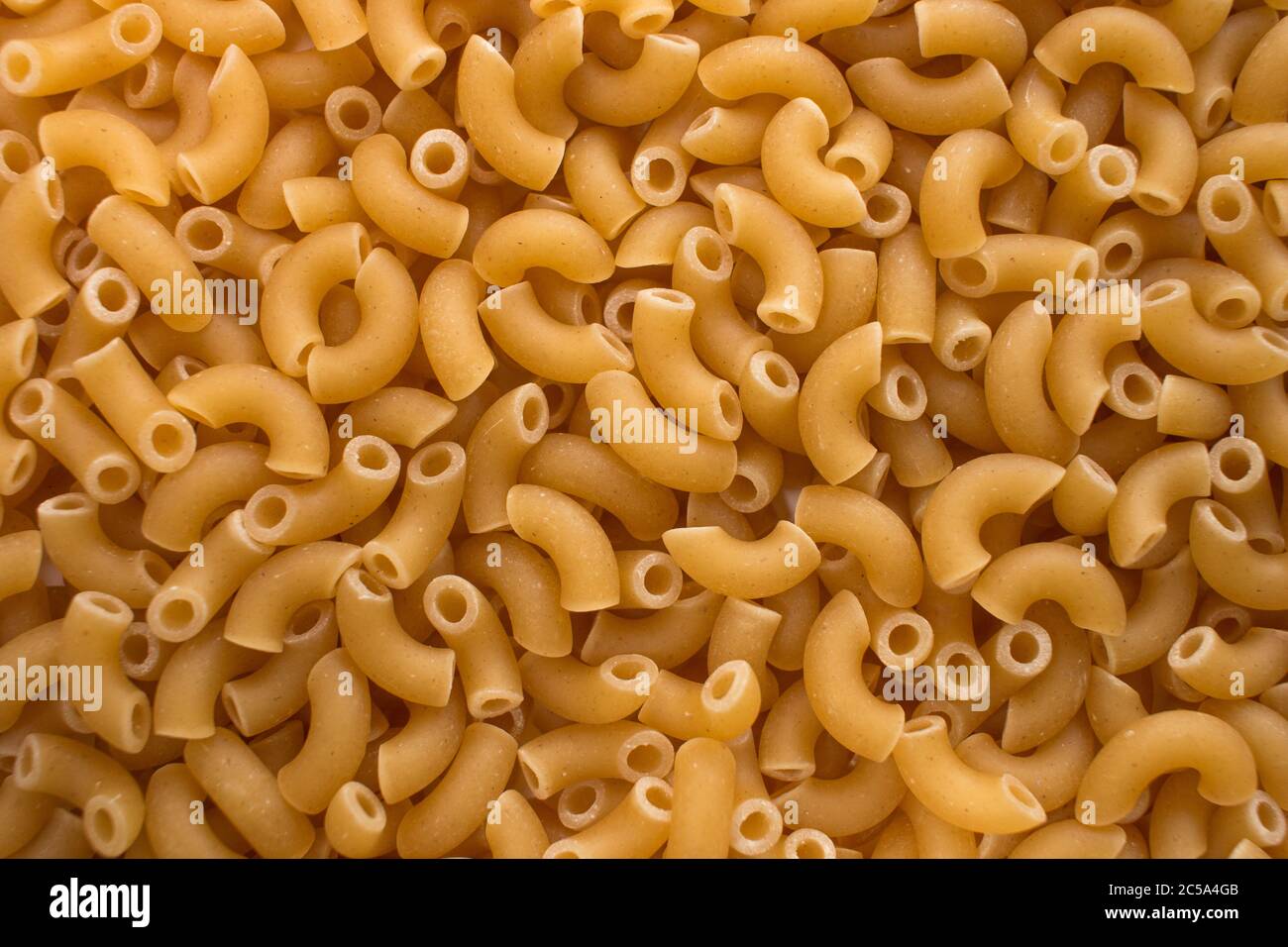 RAW Ellbogen Makkaroni Nahaufnahme Hintergrund Textur Bild. Mediterrane Küche. Stockfoto