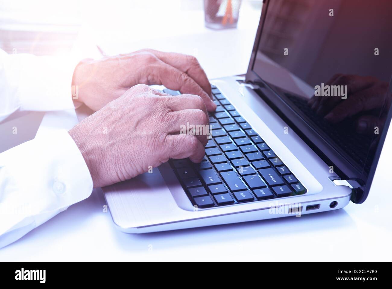 Nahaufnahme eines Mannes, der an seinem Laptop-Computer mit einem leeren Bildschirm sitzt. Stockfoto