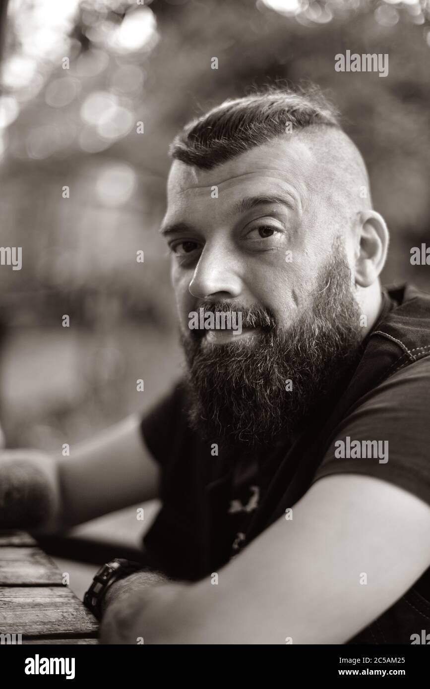 Mann mit Bart auf einem Hintergrund von Grün. Großes Gesichtsbild eines bärtigen Mannes von 40 Jahren. Vollformat. Stockfoto