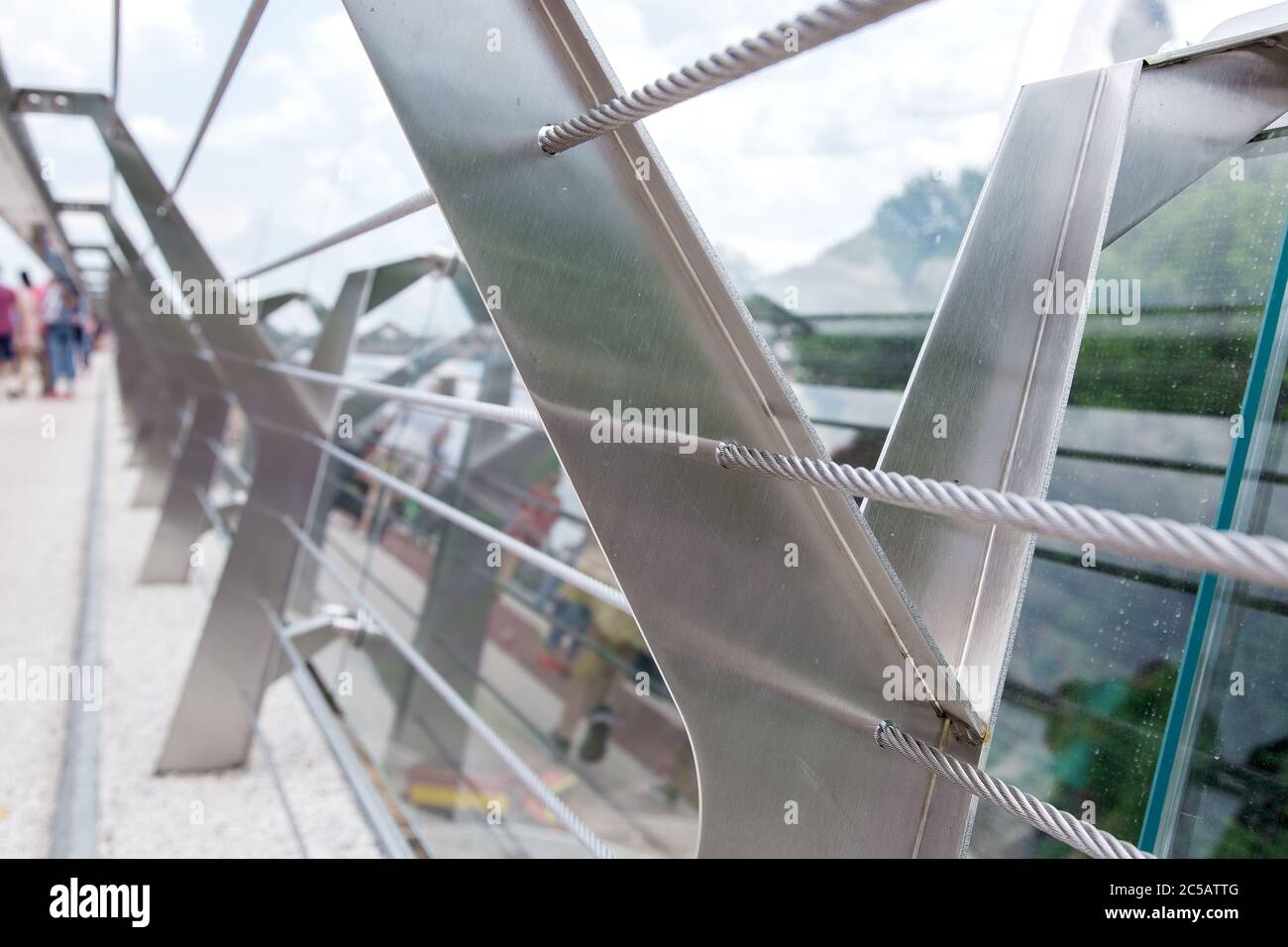 Glasbrücke mit Zugstahlseilen und Stahlgeländerstützen. Stockfoto