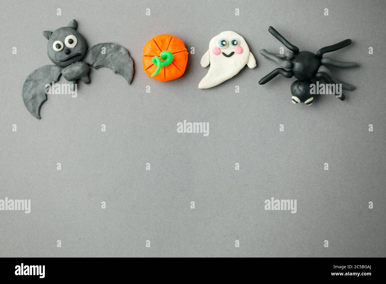 Halloween Kürbisse, Geister, Fledermaus und Spinne für saisonale Urlaub Halloween Tage Festival schaffen aus Farbe Ton auf grauem Hintergrund, DIY-Idee für Kinder, Stockfoto