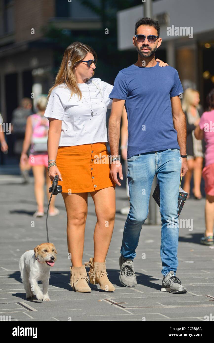 Italienisches Paar, das in der Via Sparano da Bari seinen Welpen spazierengeht. Bari, Italien Stockfoto