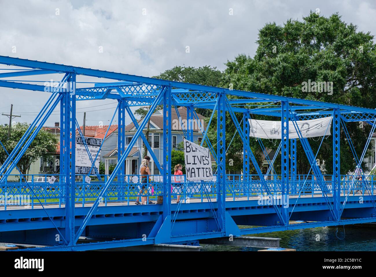 New Orleans, LA/USA - 27. Juni 2020: Magnolia Brücke über Bayou St. John mit Black Lives Matter Zeichen und Familie vorbei Stockfoto
