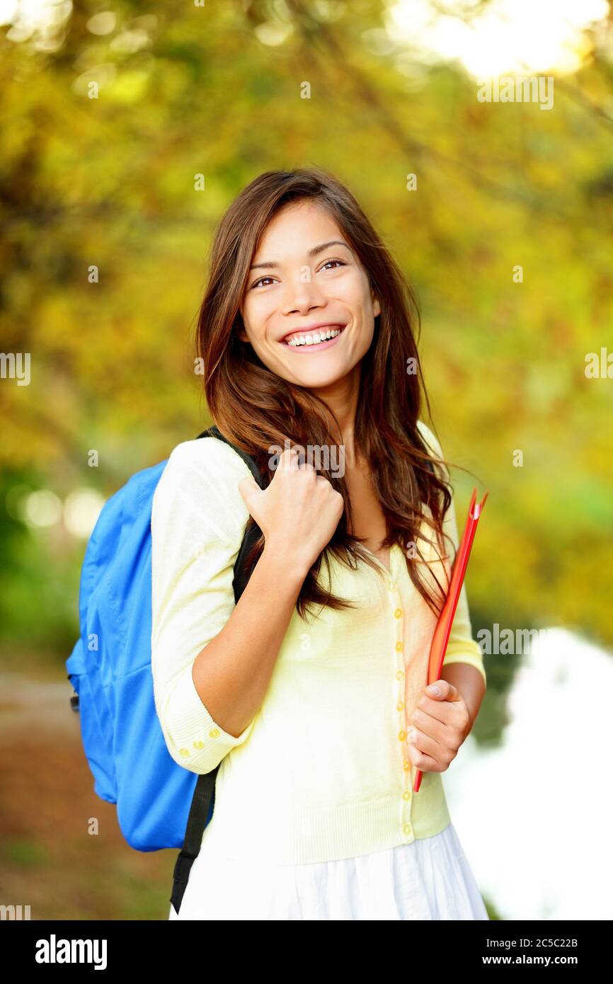 Asiatische Student Mädchen zurück zur Schule Universität. Schöne Frau hält Bücher im Herbst Hintergrund. Asiatische Student Mädchen auf Universität Hochschule Campus Park lächelnd glücklich. Gemischte Rasse Asian kaukasischen Mädchen. Stockfoto