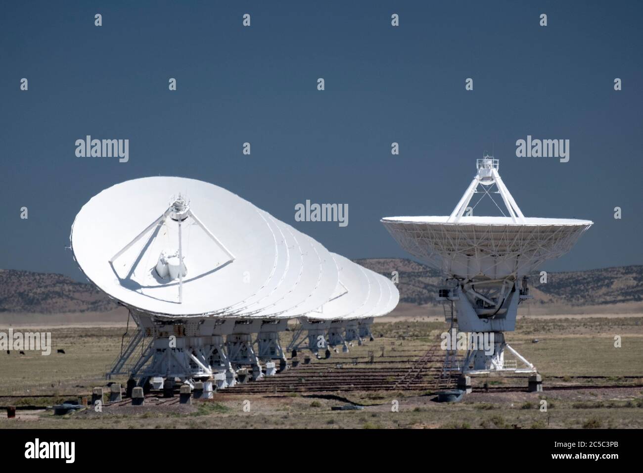 Reihe von mehreren Radioteleskopen in einer Reihe mit einer einfachen Schale, die nach oben auf das Very Large Array (VLA) gerichtet ist Stockfoto