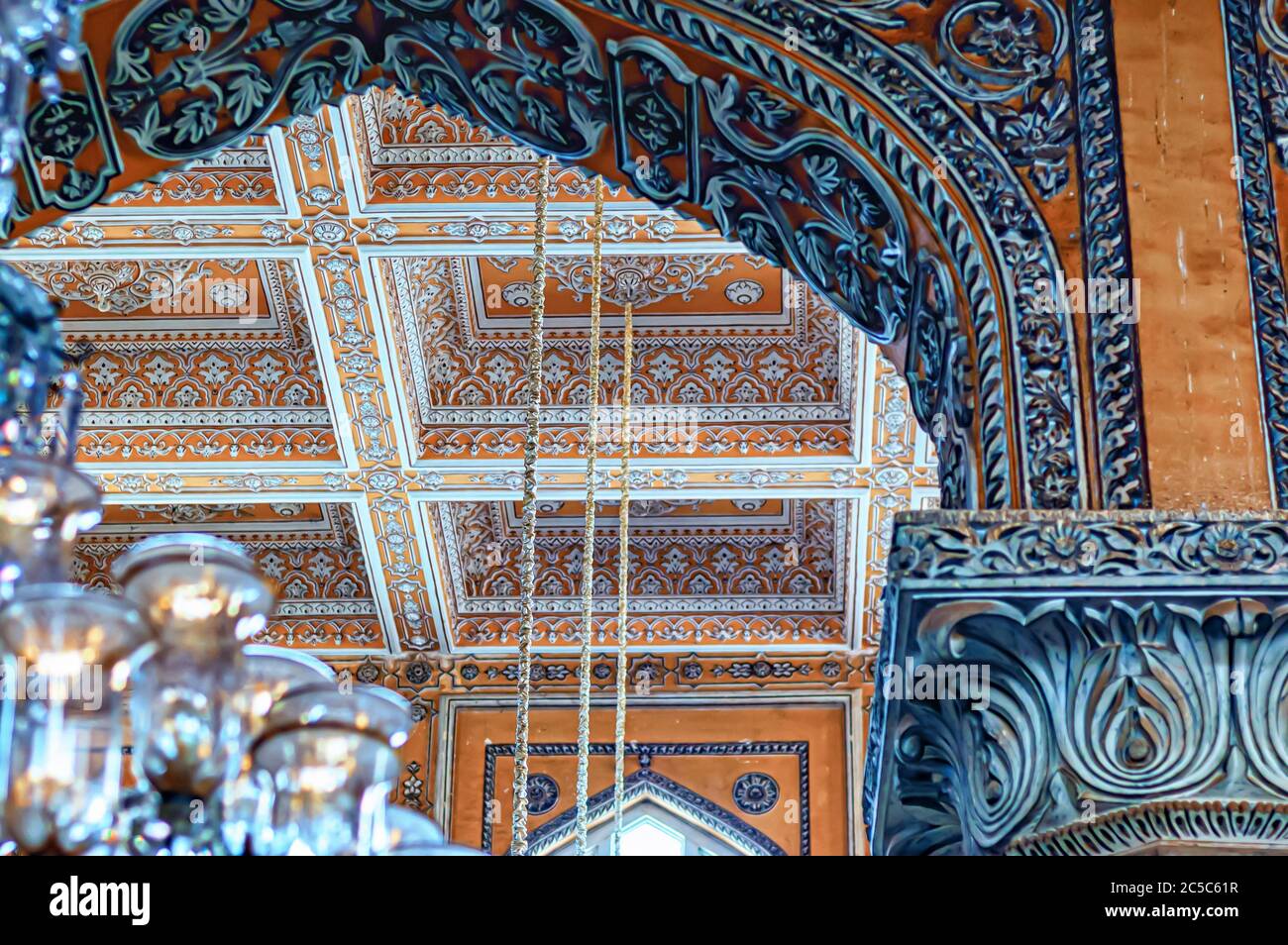 Die verzierten und verschlungenen Stuckarbeiten und floralen Schnitzereien schmücken das Dach und die imposanten Bögen im Chowmahalla Palace, Hyderabad, Telangana, Indien. Stockfoto