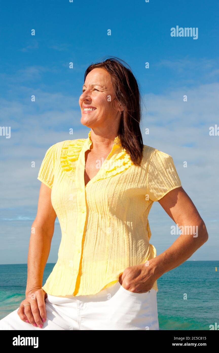 Porträt von entspannten und attraktiv aussehende ältere Frau genießen aktiven Ruhestand und Freizeit auf See, isoliert mit Meer und blauen Himmel als backgr Stockfoto