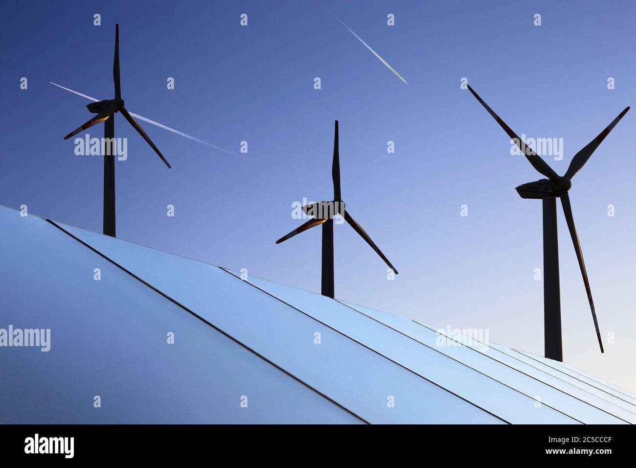 Symbolbild Energiewende: Solardach mit Windkraftanlagen im Hintergrund (Composing) Stockfoto