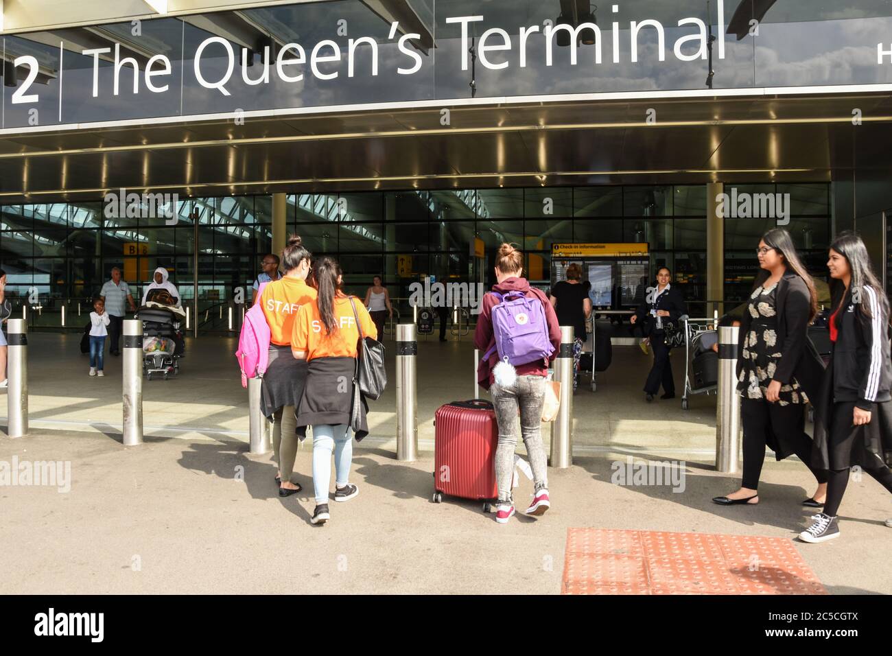 Passagiere und Mitarbeiter, die das Queens Terminal, den Flughafen Heathrow, London, Großbritannien, betreten und verlassen Stockfoto