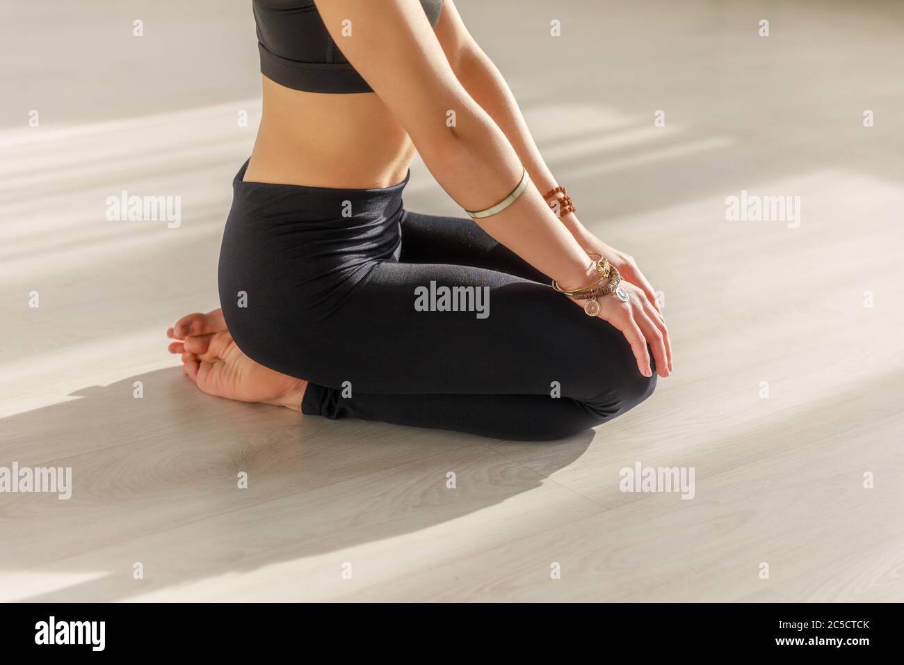 Beschnittene Ansicht der Frau mit barfuß tun Seiza Übung auf dem Boden in Yoga-Studio Stockfoto