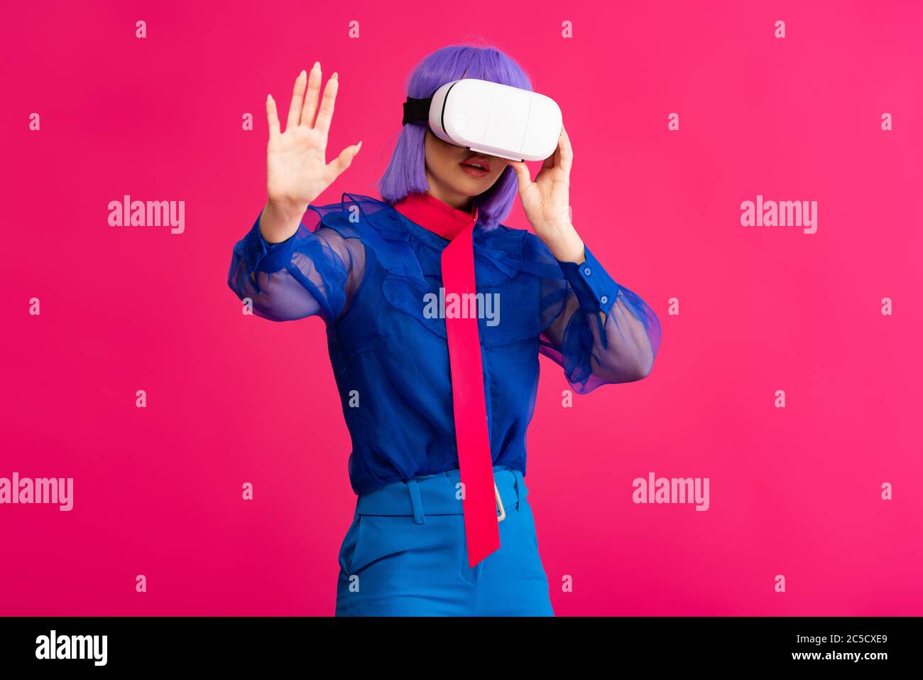 Modische Pop-Art Mädchen in blauer Bluse mit vr Headset, isoliert auf rosa Stockfoto