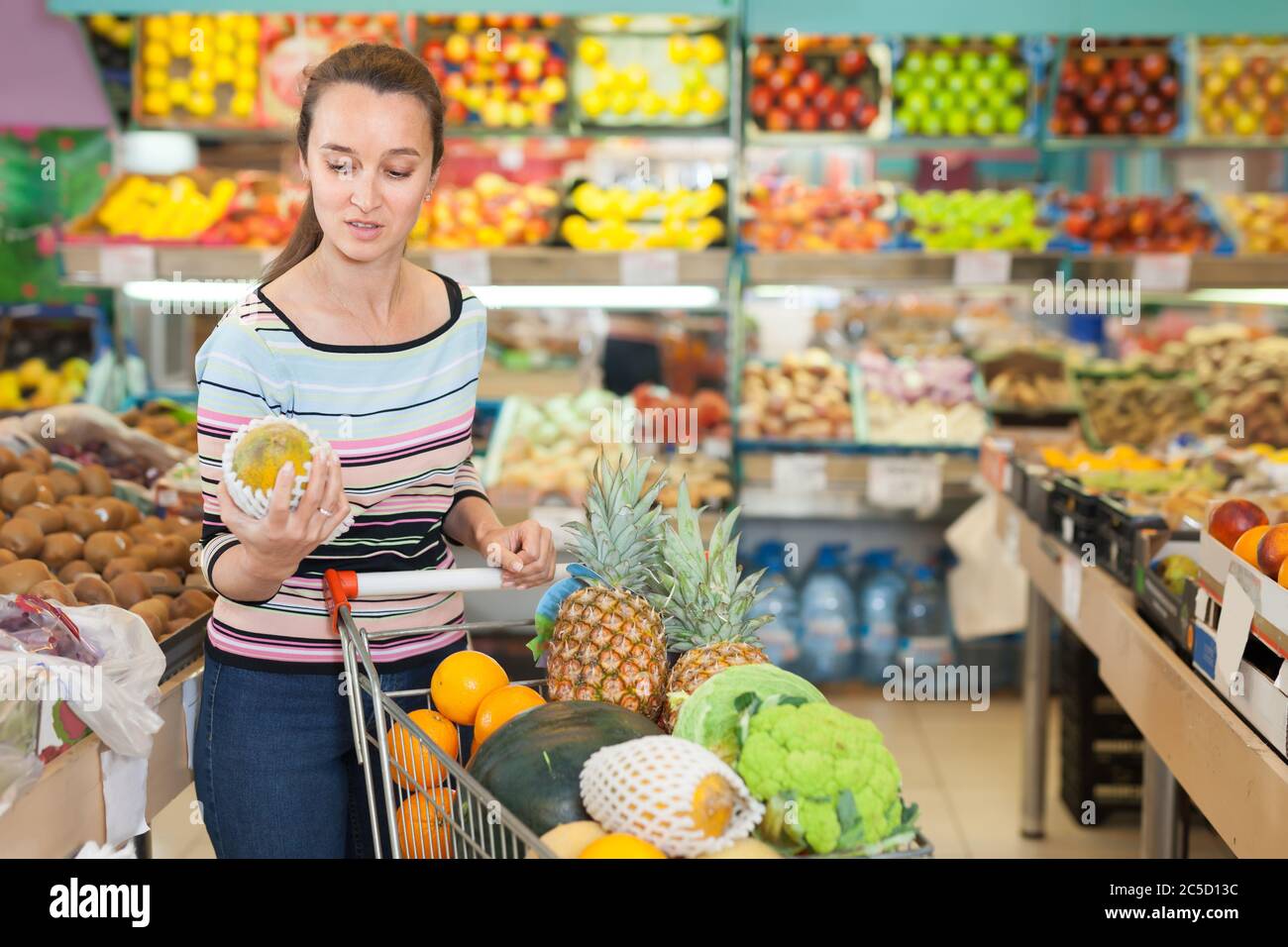 Feines Mädchen bei Obst und Gemüse Abschnitt des Ladens Stockfoto