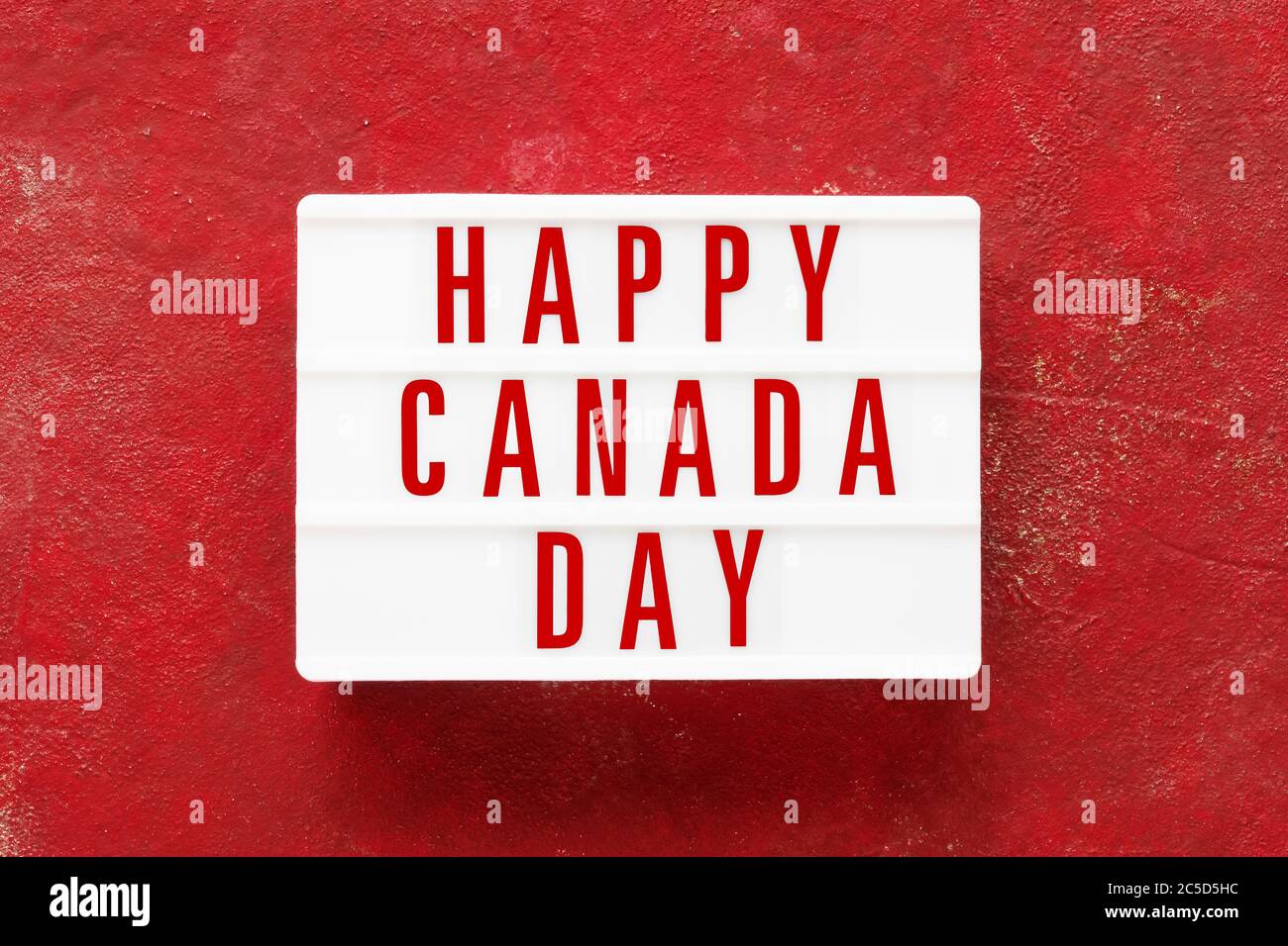 HAPPY CANADA TAG in Leuchtkasten auf rotem Hintergrund geschrieben. Datum des Unabhängigkeitstages. Draufsicht, Kopierbereich Stockfoto