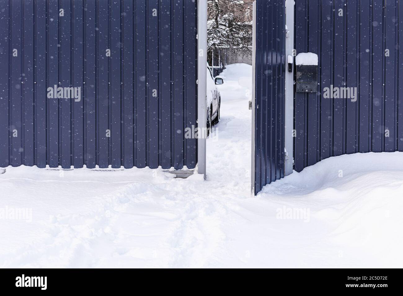 Fußabdrücke im Schnee. Schneeverwehungen. Winter, Zaun, Schnee an frostigen Tagen. Öffnen Sie das Tor im Zaun an verschneiten Tagen. Zaun im Schnee. Stockfoto