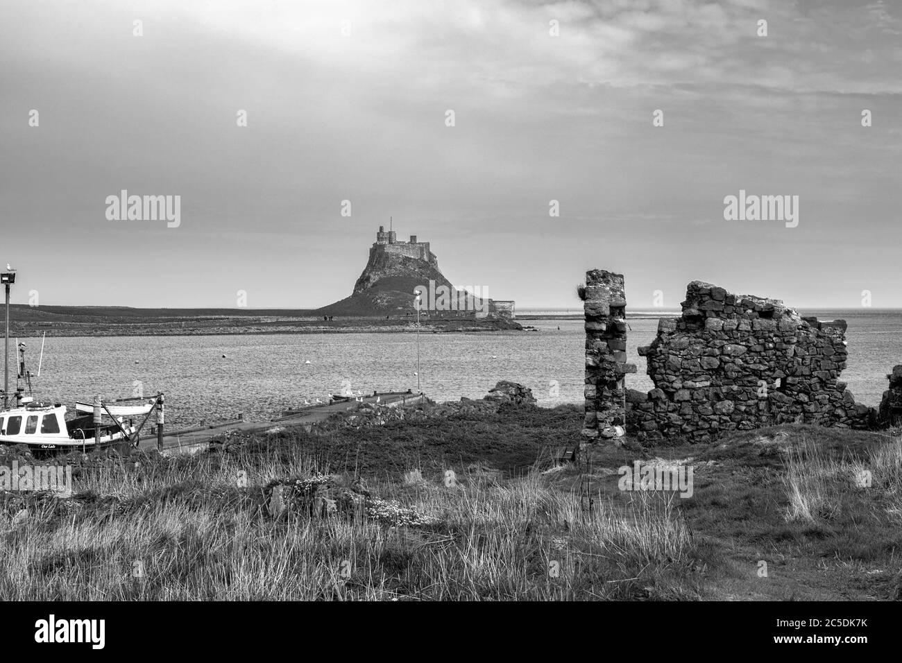 Das Schloss und der Hafen von The Common, Lindisfarne, Holy Island, Northumberland, England, Großbritannien. Schwarz-Weiß-Version Stockfoto