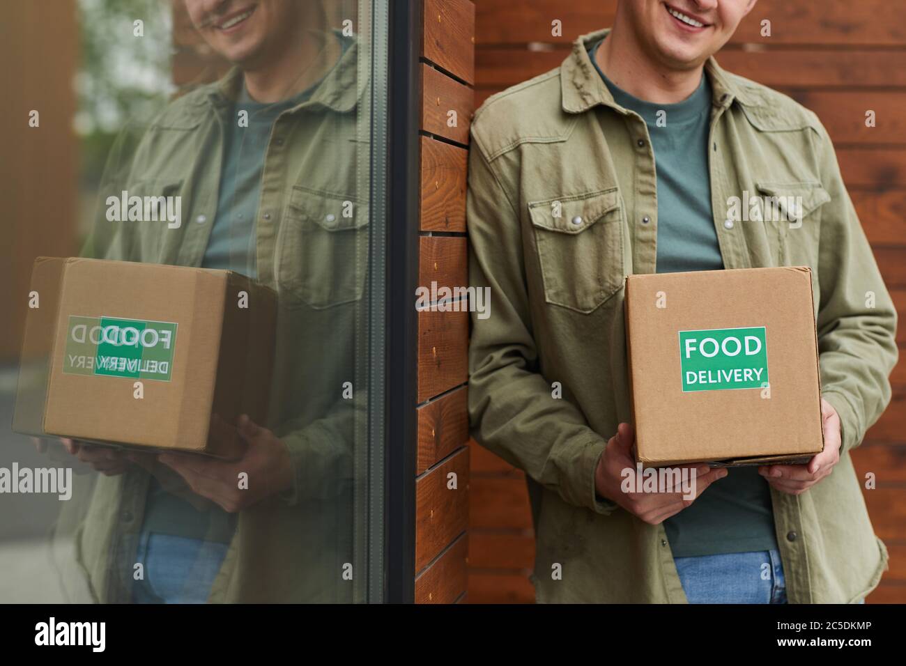 Nahaufnahme von jungen Mann Bestellung Lebensmittel Lieferung und bekommen es er im Freien stehen Stockfoto