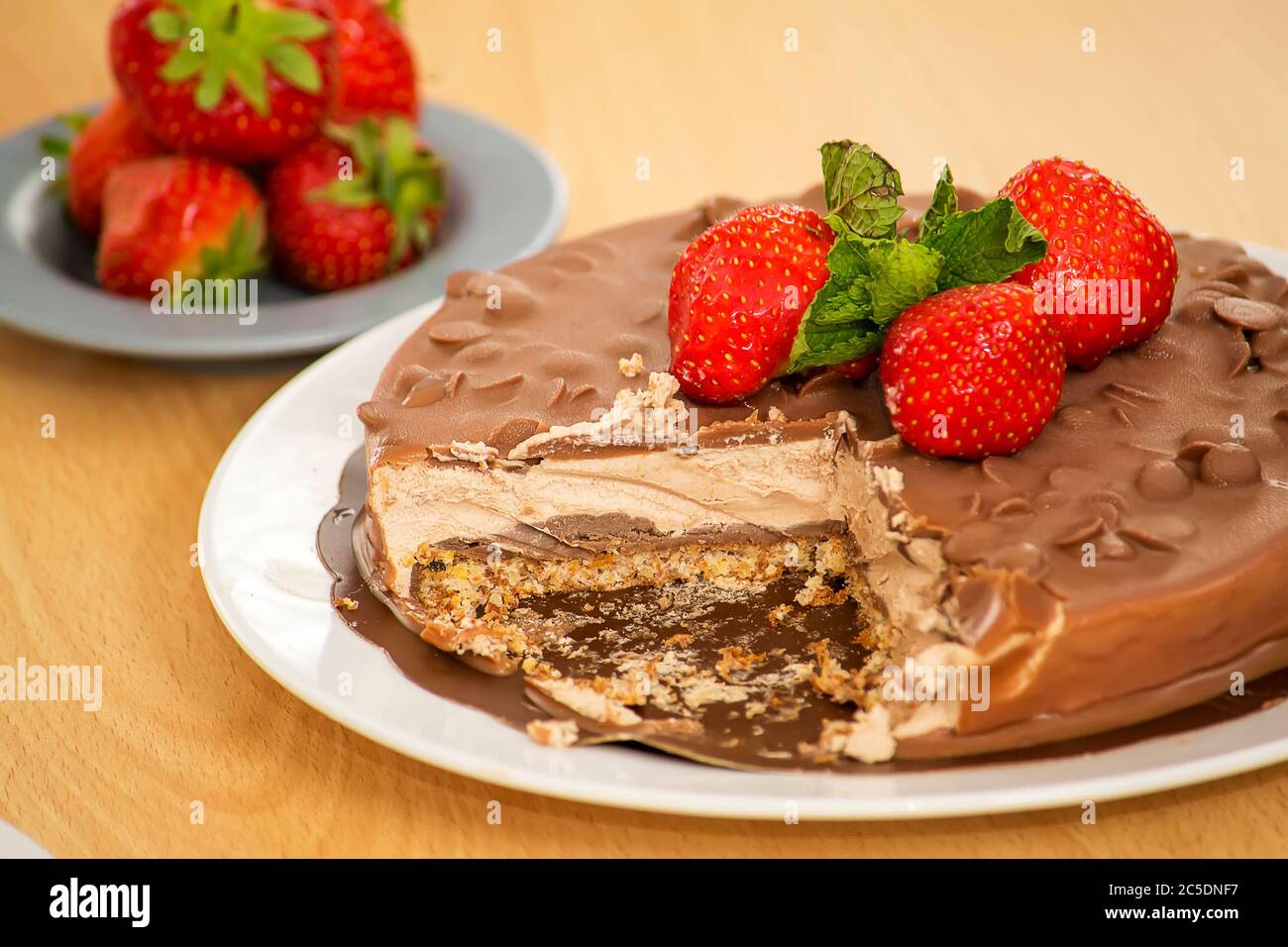 Schokoladenkuchen mit Erdbeeren, Mandeln und Minzblättern. Stockfoto
