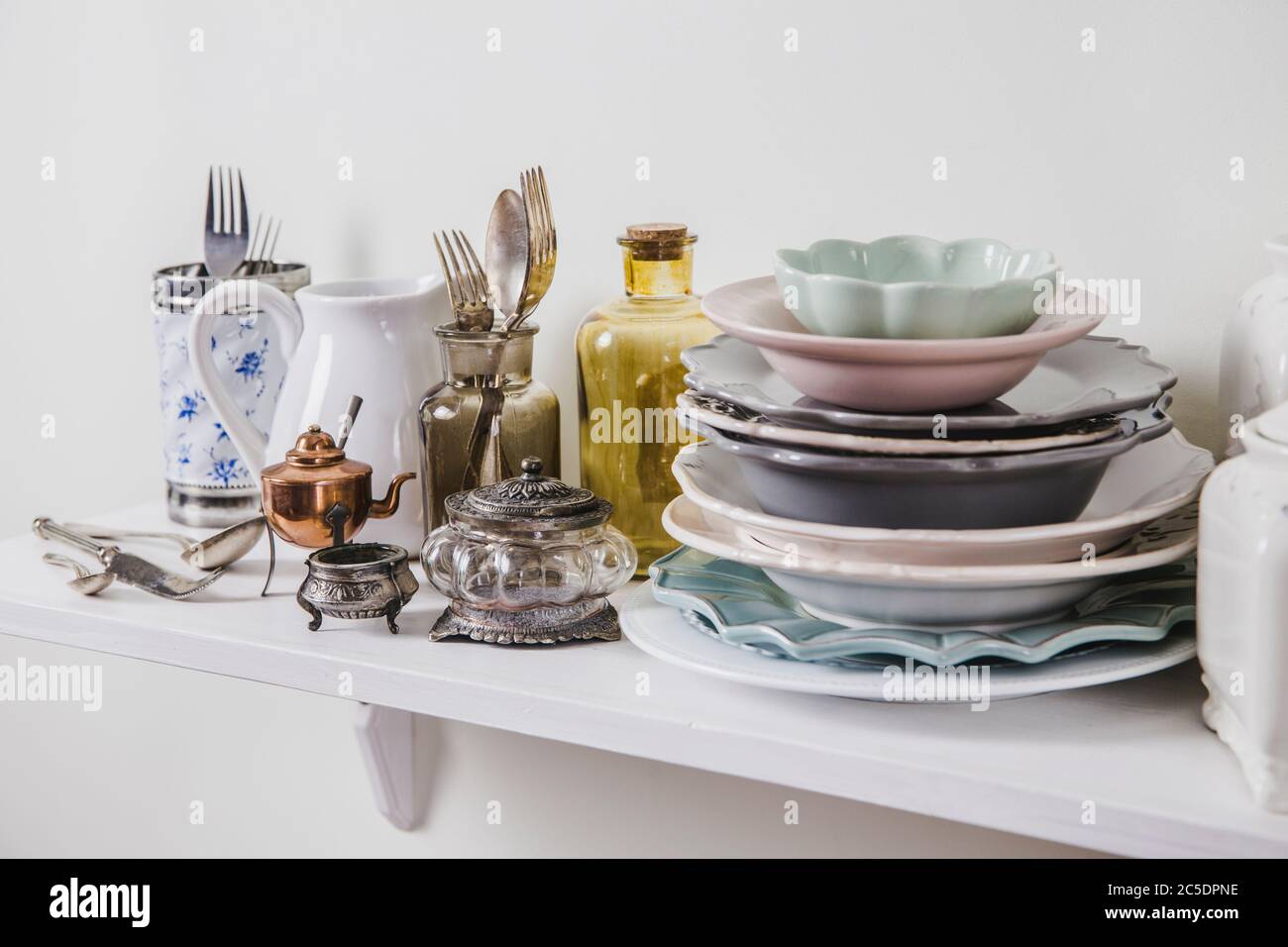 Kaufen Sie alte Vintage romantische Geschirr in gebrauchten Shop-Konzept. Stapel von wertvollen alten Geschirr auf Lagerregal für die Küche. Stockfoto