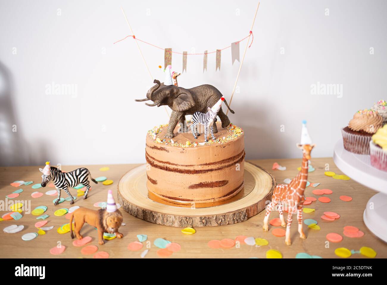 Schokolade Geburtstagskuchen mit winzigen Wildtieren auf einem Holztisch dekoriert Stockfoto
