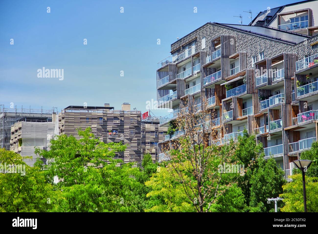 Paris, Frankreich - 28. Juni 2015: Eco-Quartier Clichy-Batignolles. Neue Moderne Architektur. Park Martin Luther King. Grüne Baumkronen und Baufakade Stockfoto