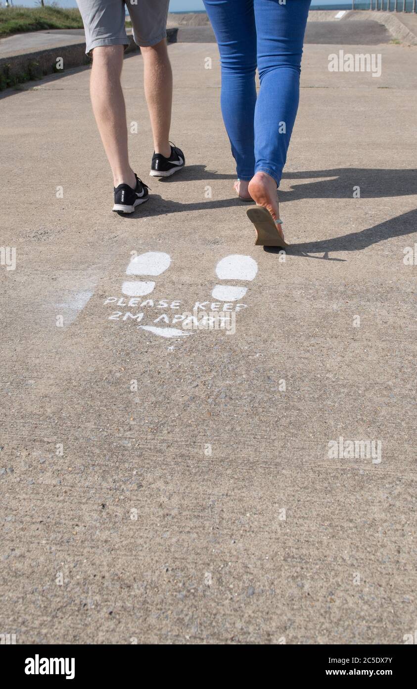 2m soziale Fernwarnung auf einen konkreten Weg gemalt. Stockfoto