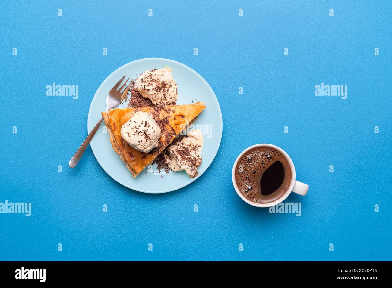 Apfelstückchen mit goldener Kruste serviert mit Vanilleeis und einem heißen Kaffee auf einem blauen Tisch. Flach mit Apfeltarte legen. Thanksgiving Dess Stockfoto