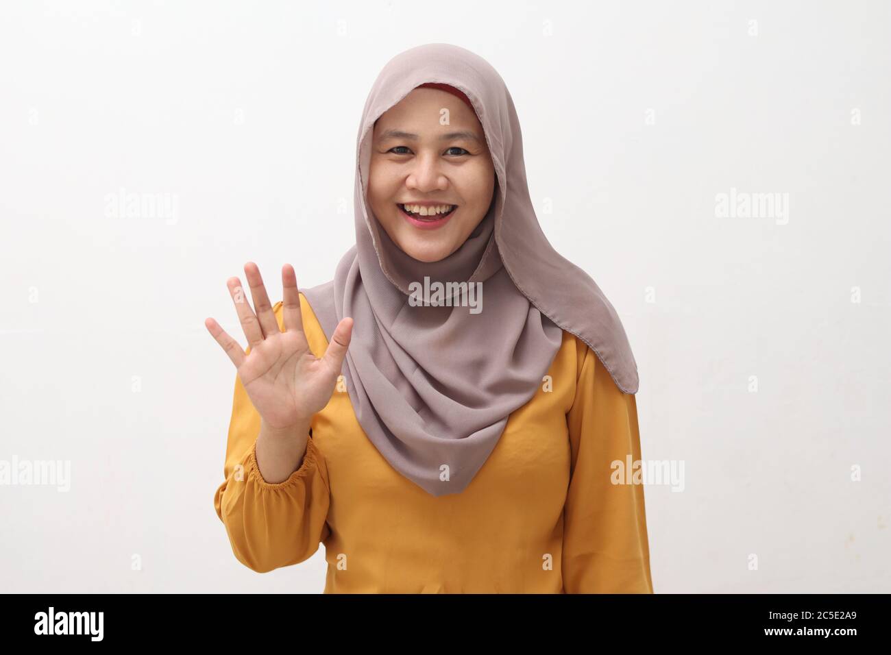 Glücklich fröhlich schöne asiatische muslimische Dame trägt Hijab winken Kamera, tun Selfie oder Videoanruf Geste, isoliert auf weiß Stockfoto