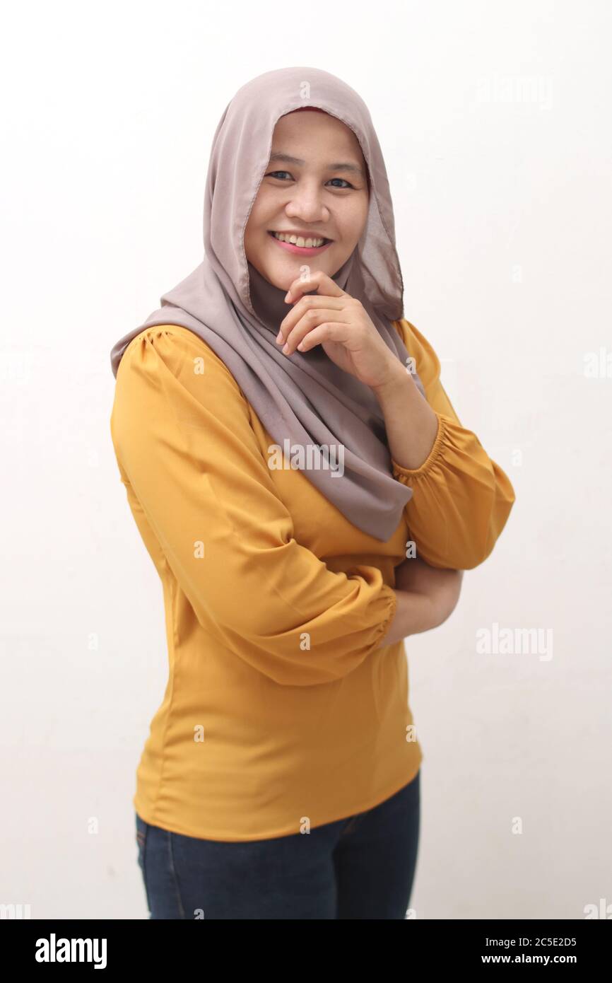 Portrait einer schönen asiatischen muslimischen Frau, die Hijab trägt, lächelt an der Kamera, isoliert auf Weiß Stockfoto