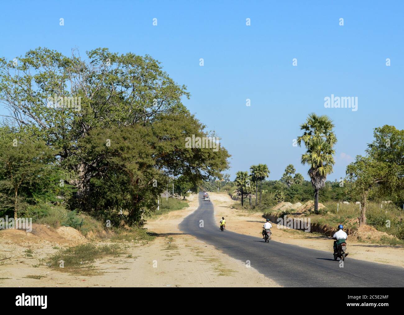 Motorräder auf der Straße auf dem Land in Myanmar, Südostasien. Wildes Land und kleine Straße und Bäume. Stockfoto