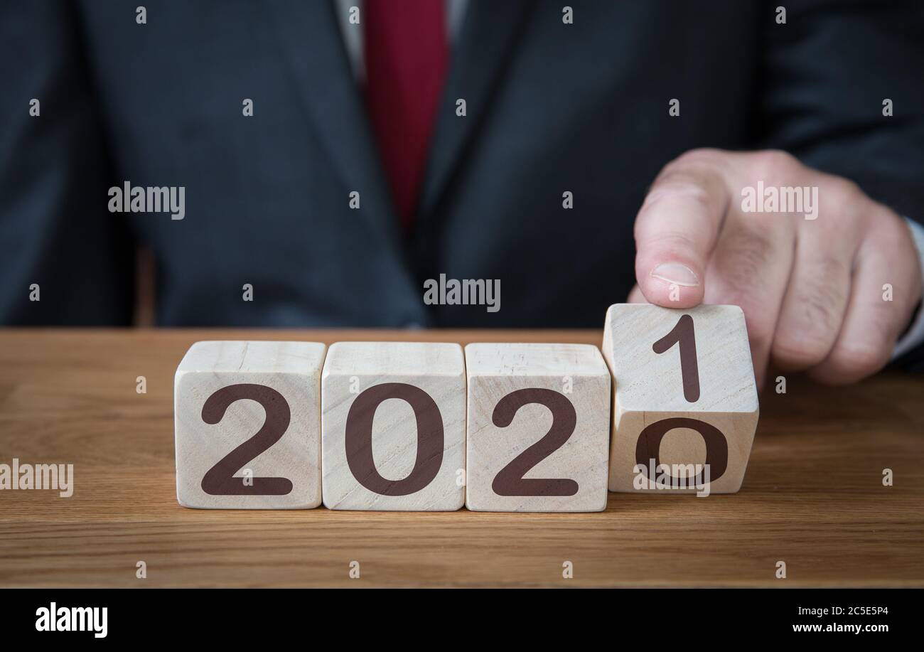 Eine Nahaufnahme eines Geschäftsmannes, der zuversichtlich in die Zukunft blickt und das Datum eines Kalenders auf 2021 ändert Stockfoto