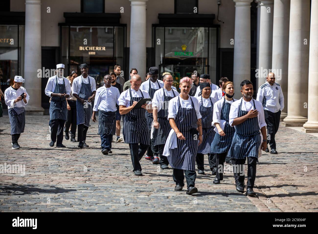 Covent Garden, London, Großbritannien, 2. Juli 2020. Chef's und Küchenpersonal gehen über die piazza in Covent Garden, während sich der Dienstleistungssektor auf den Super Saturday vor den Einschränkungen des Coronavirus-Sperrens vorbereitet wird und Restaurants und Bars dieses Wochenende in London, Großbritannien geöffnet sind 02.Juli 2020 Covent Garden, London, Großbritannien Credit: Clickpics/Alamy Live News Stockfoto