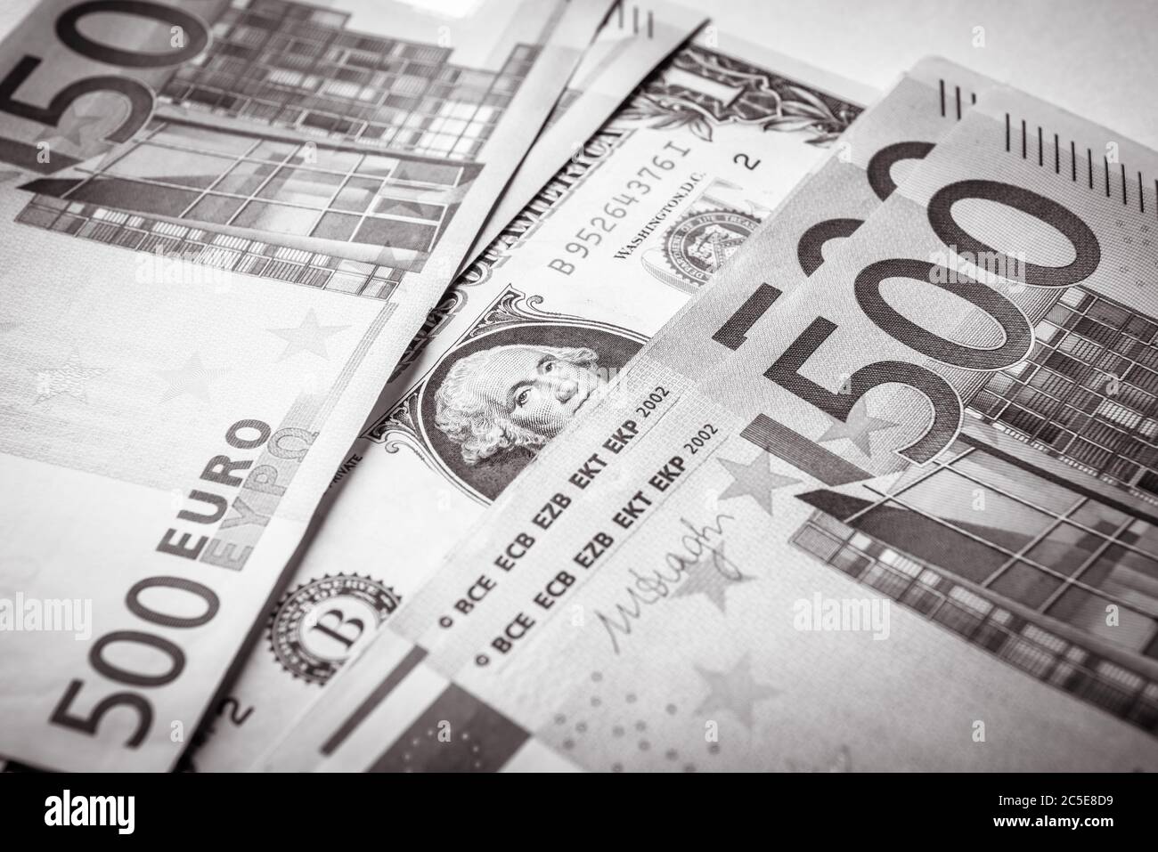 1 Dollar-Schein im Vergleich zu 500 Euro-Geldscheinen. Blick von oben auf Geldkassieren in Schwarz und Weiß. Währung der Europäischen Union gegen eine amerikanische Dollarnote. Nachteile Stockfoto