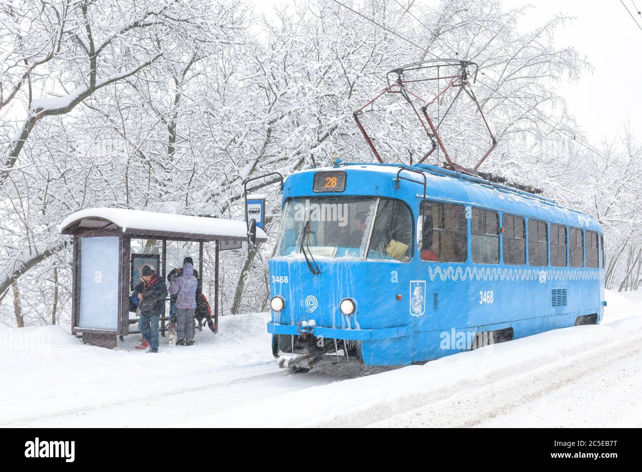 Moskau – 4. Februar 2018: Straßenbahn während Schneesturm im Winter, Russland. Die Menschen warten auf den städtischen Verkehr an der ICE-Haltestelle. Kälte und Schneefall in der Stadt. Gefrorene Straßenbahn auf Schnee Stockfoto