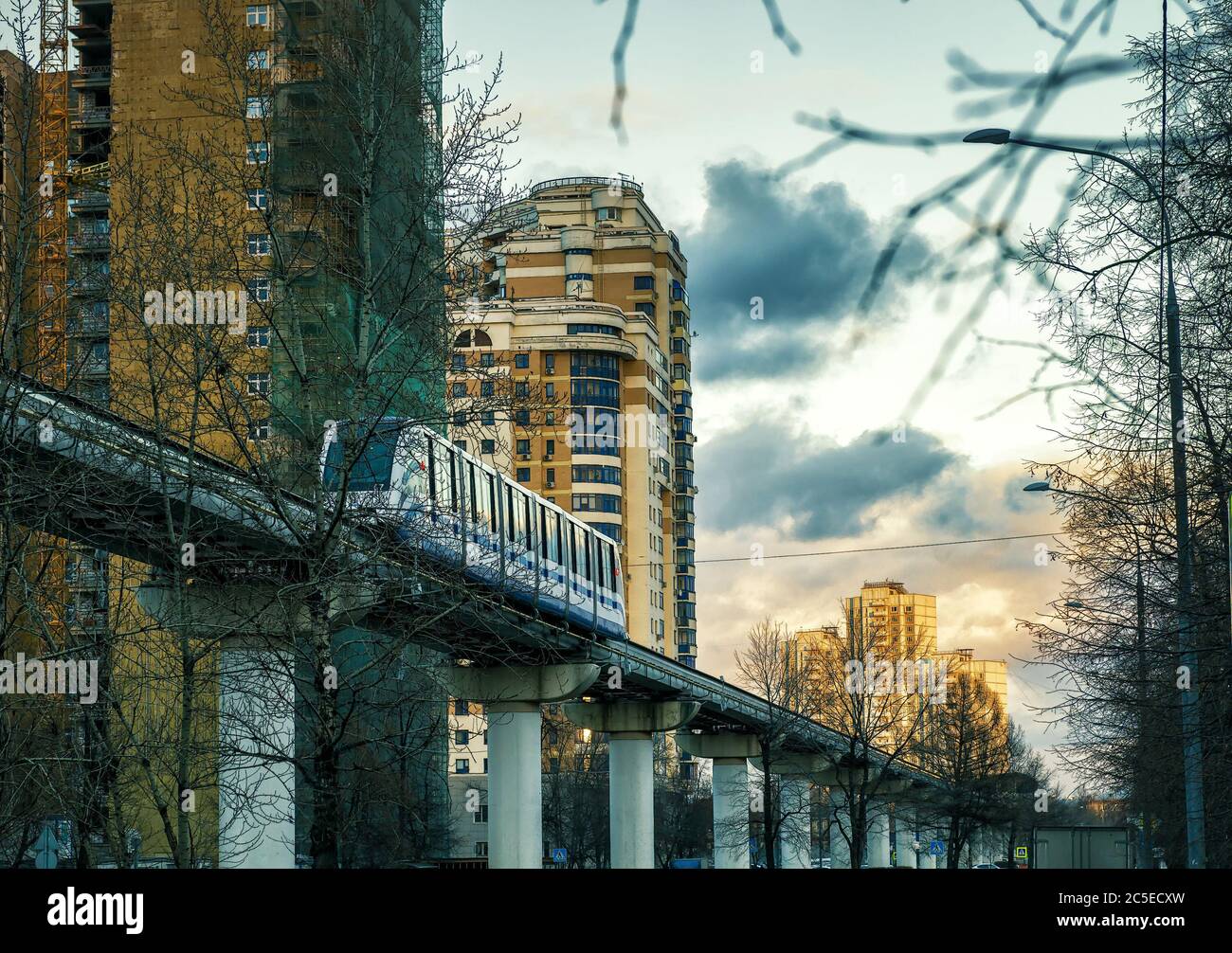 Eine Einschienenbahn fährt bei Sonnenuntergang in Moskau, Russland, über der Straße. Stockfoto