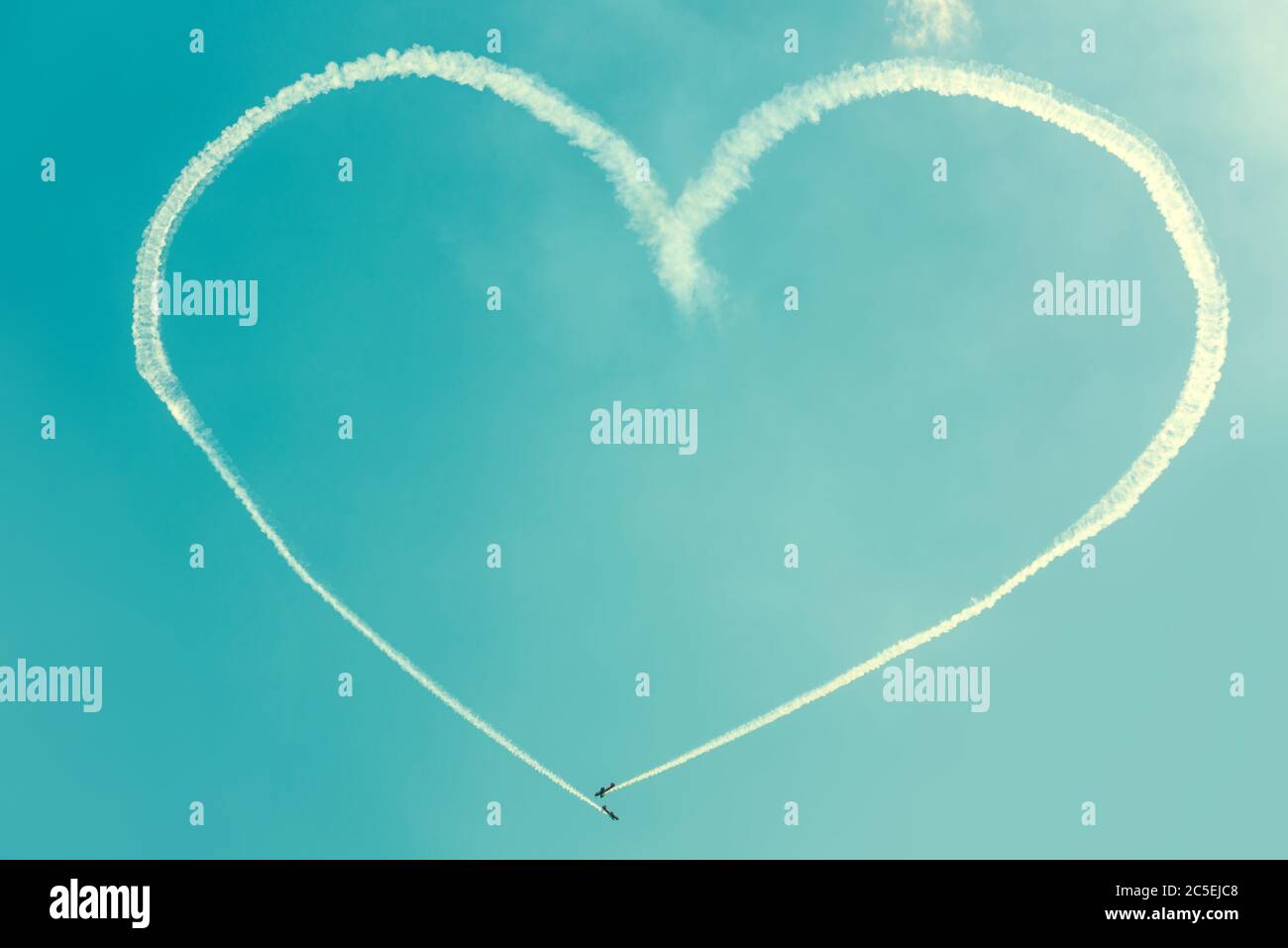 Ein Herz am blauen Himmel von zwei skywriting kleinen Flugzeugen bei einer Flugshow Stockfoto