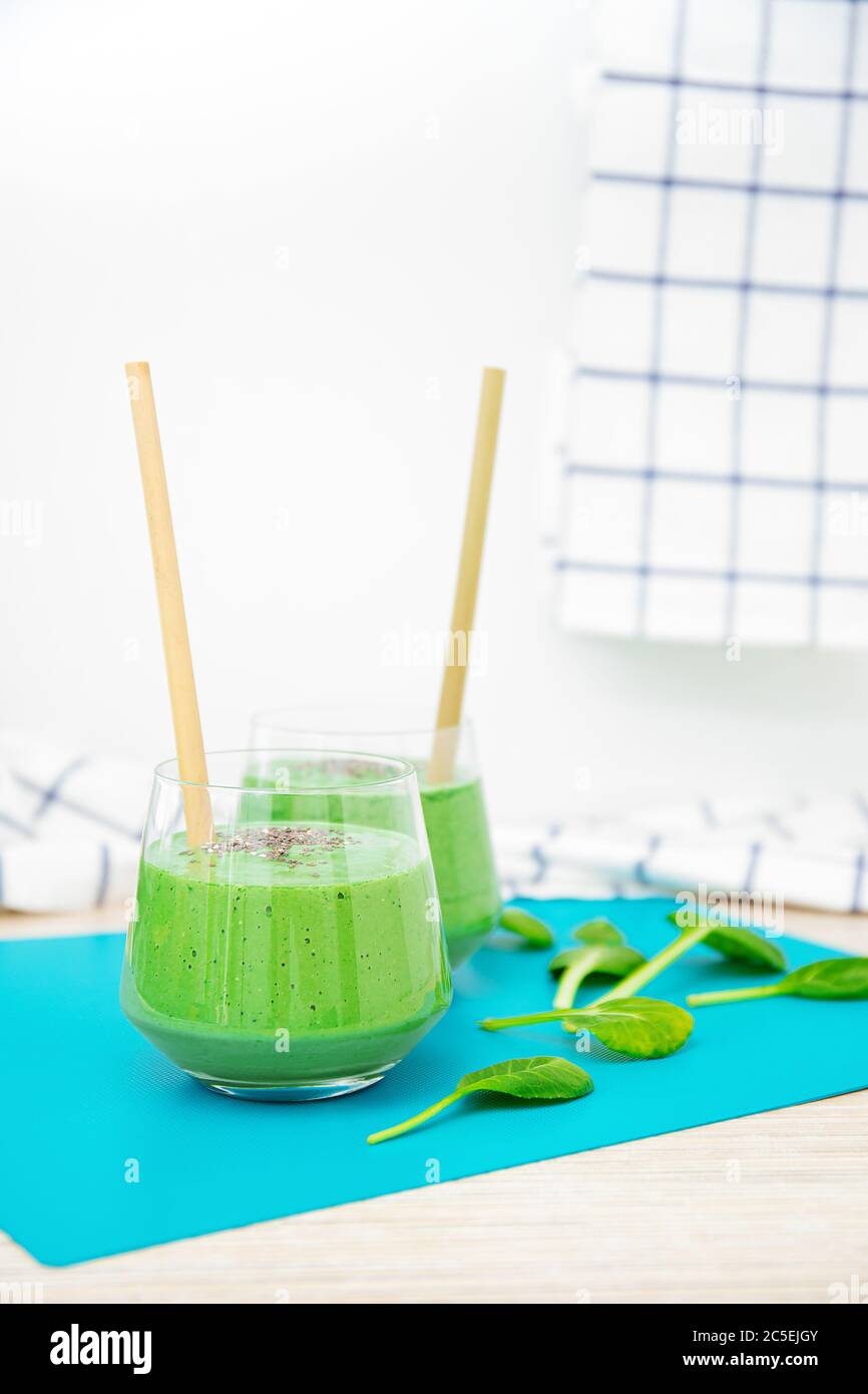 Köstliche Spinat Smoothie isoliert auf weißem Hintergrund. Elegante Glas-Becher mit Smoothies und Bambus-Öko-Trinkpfeifen. Spinatblätter. Stockfoto