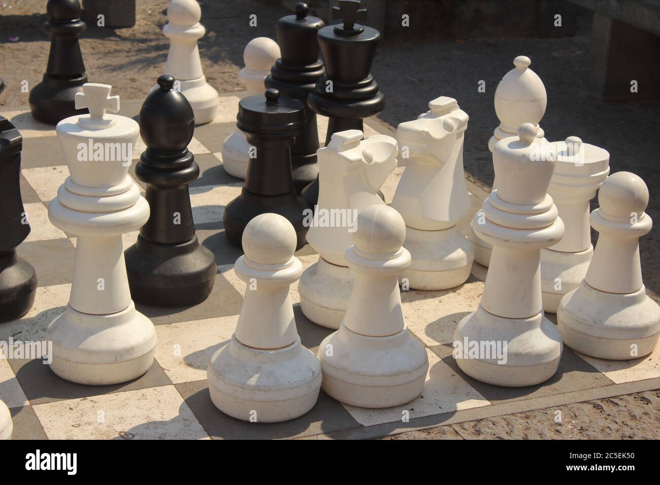 Schachspiel mit Schachbrett und Bauern auf der Straße. Geschäftskonzept Stockfoto