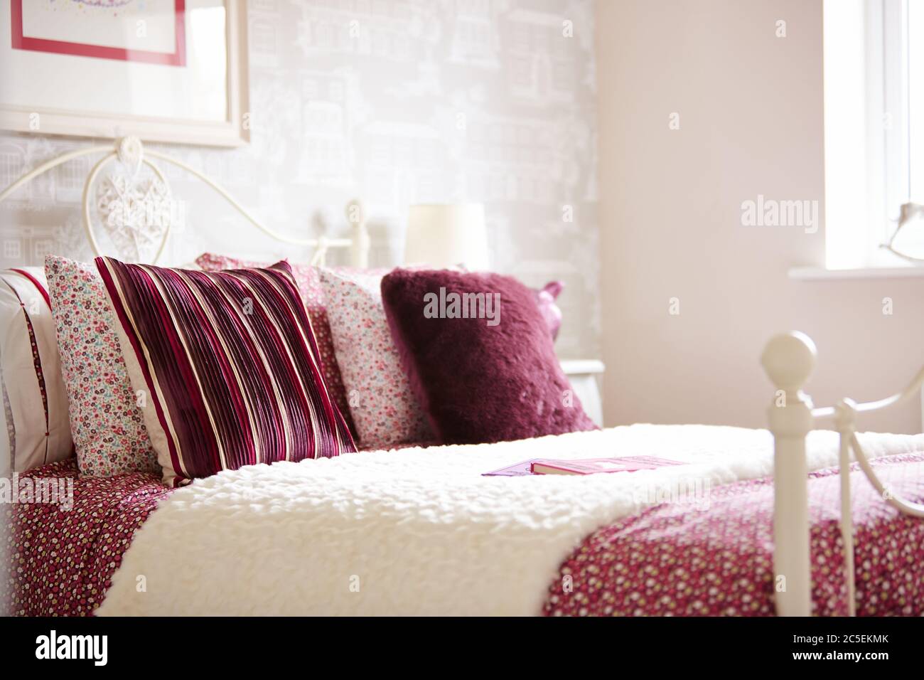 Ein Foto von bunten Kissen und Bettwäsche auf einem Bett im luxuriösen Schlafzimmer Stockfoto