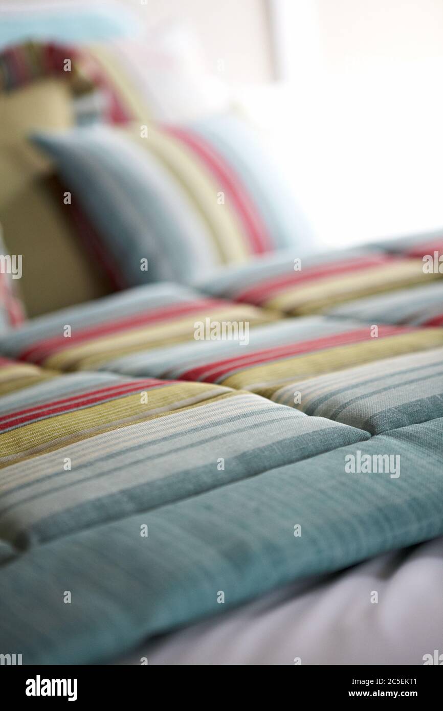 Aufnahme von bunt gestreifter Bettwäsche auf dem Bett Stockfoto