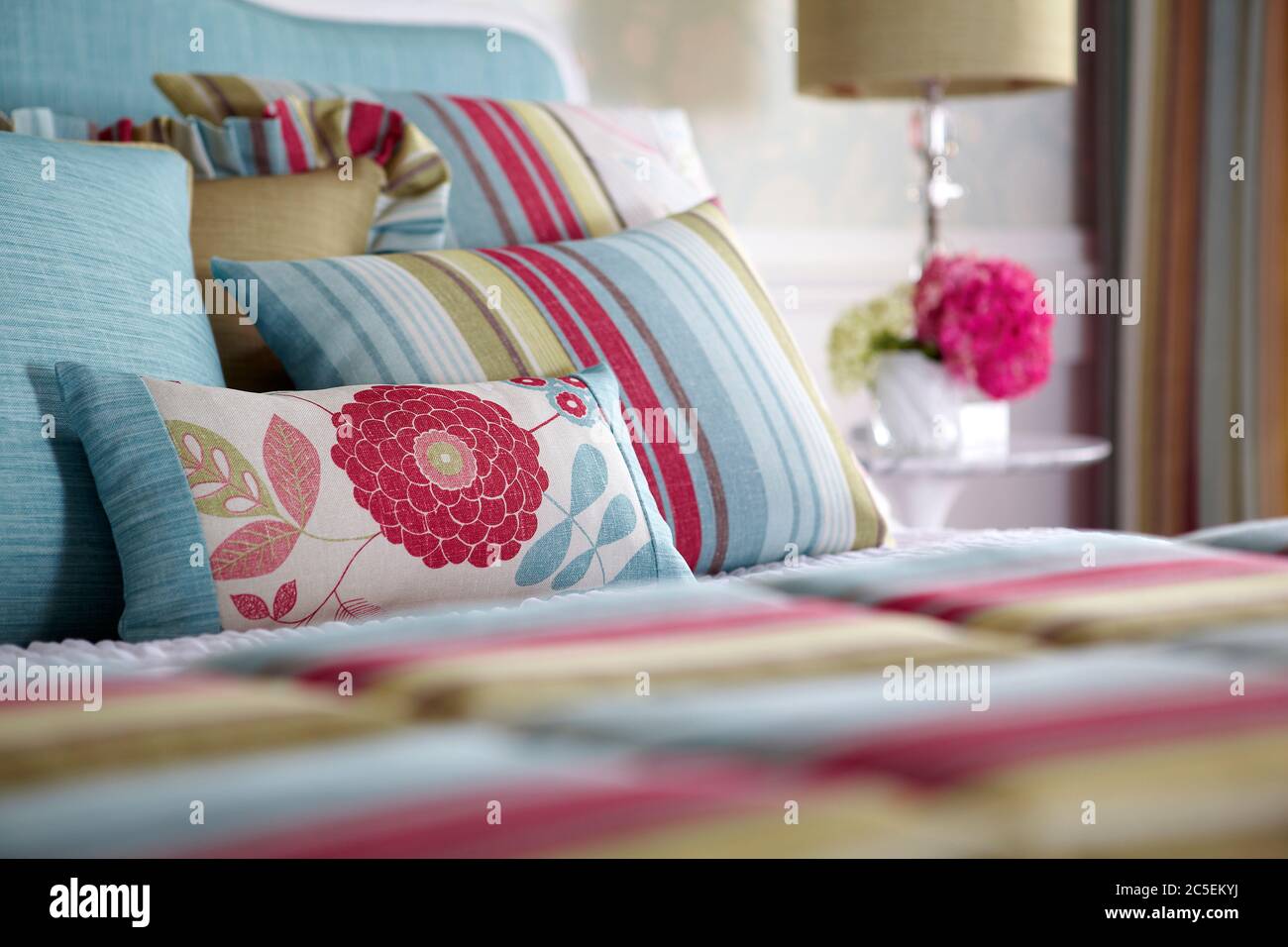 Aufnahme von mehrfarbigen Kissen auf dem Bett im modernen Schlafzimmer Stockfoto