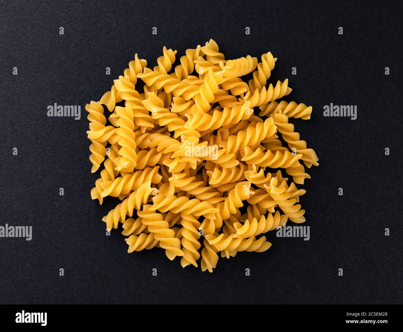 Rohe Fusilli Pasta isoliert auf schwarzem Hintergrund, Draufsicht Stockfoto