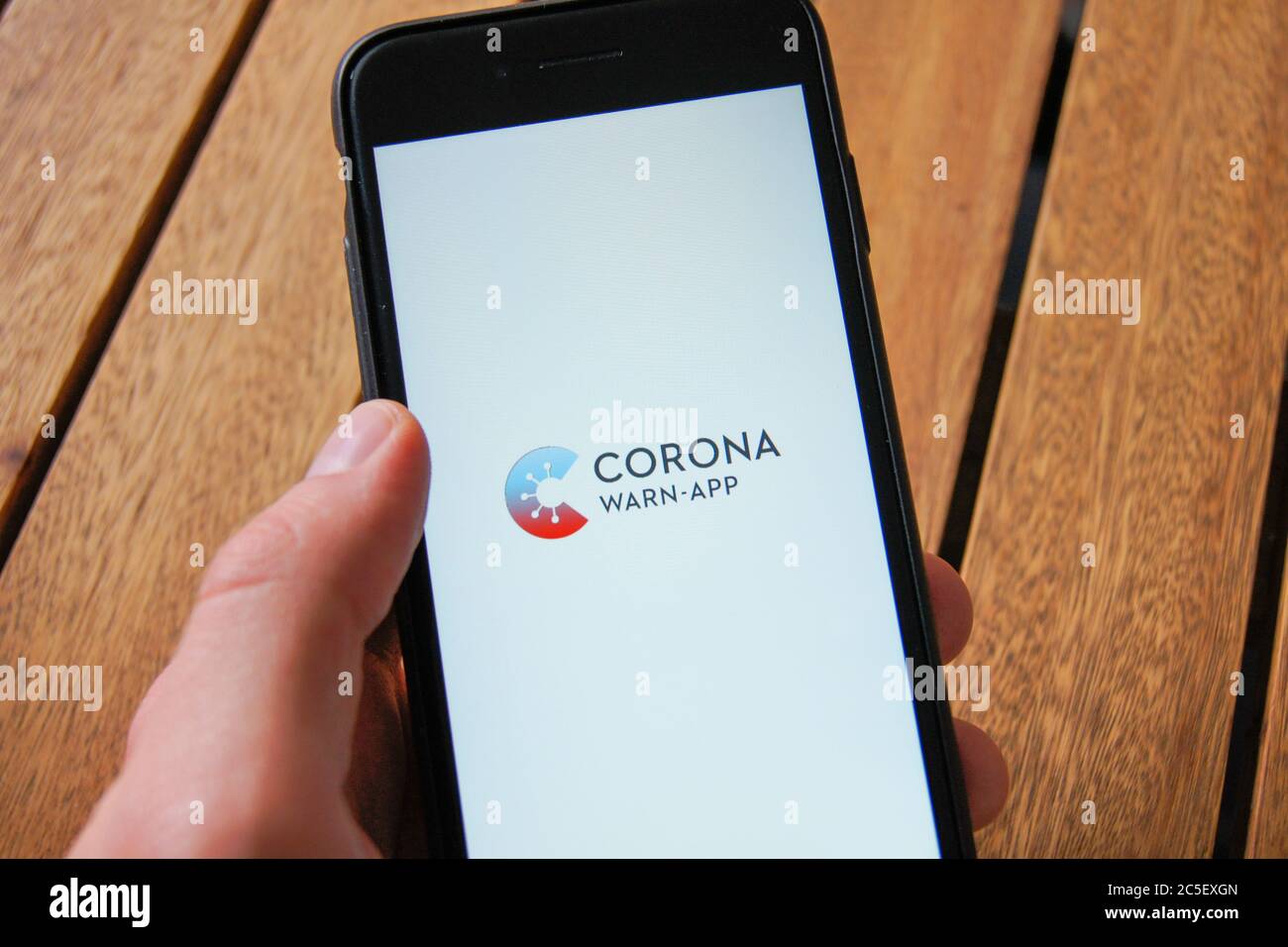 Corona Warn App der Bundesregierung auf einem Smartphone in der Hand eines Mannes. Entwickelt von SAP & Deutsche Telekom. Stockfoto