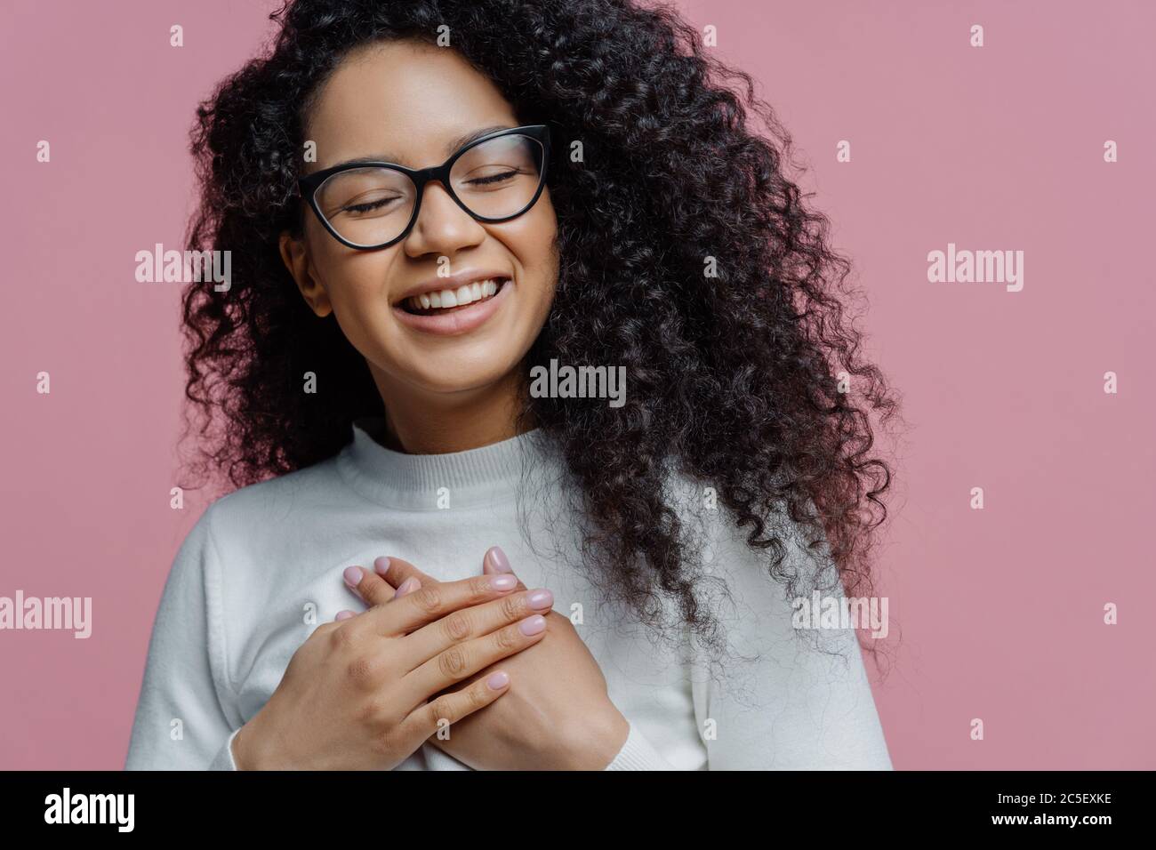 Nahaufnahme von glücklich aufrichtigen Afro-amerikanische Frau hält die Hände auf die Brust gedrückt, drückt aufrichtige Gefühle, macht Dankbarkeit Geste, fühlt sich dankbar f Stockfoto