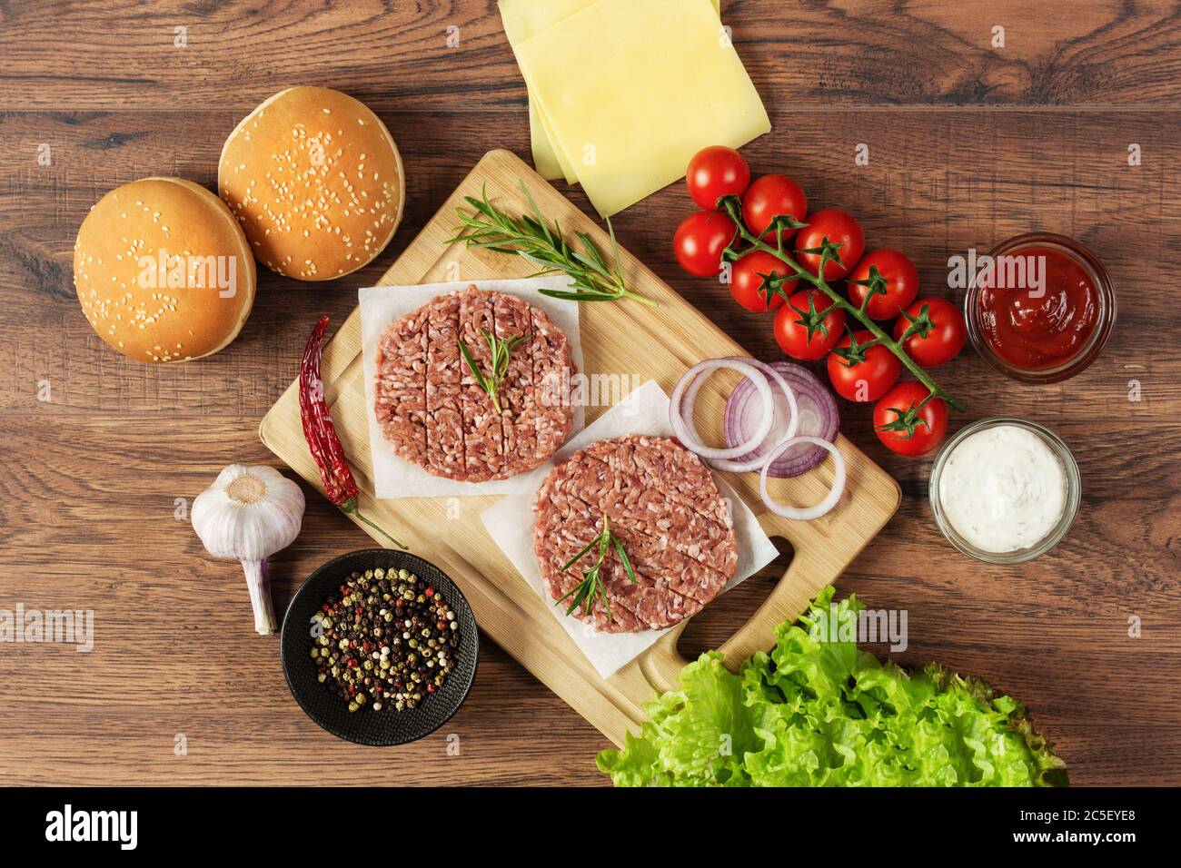 Frische Zutaten für hausgemachten Burger auf Holz Hintergrund Draufsicht. Ungesunde Ernährung, Fast-Food-Abendessen. Stockfoto