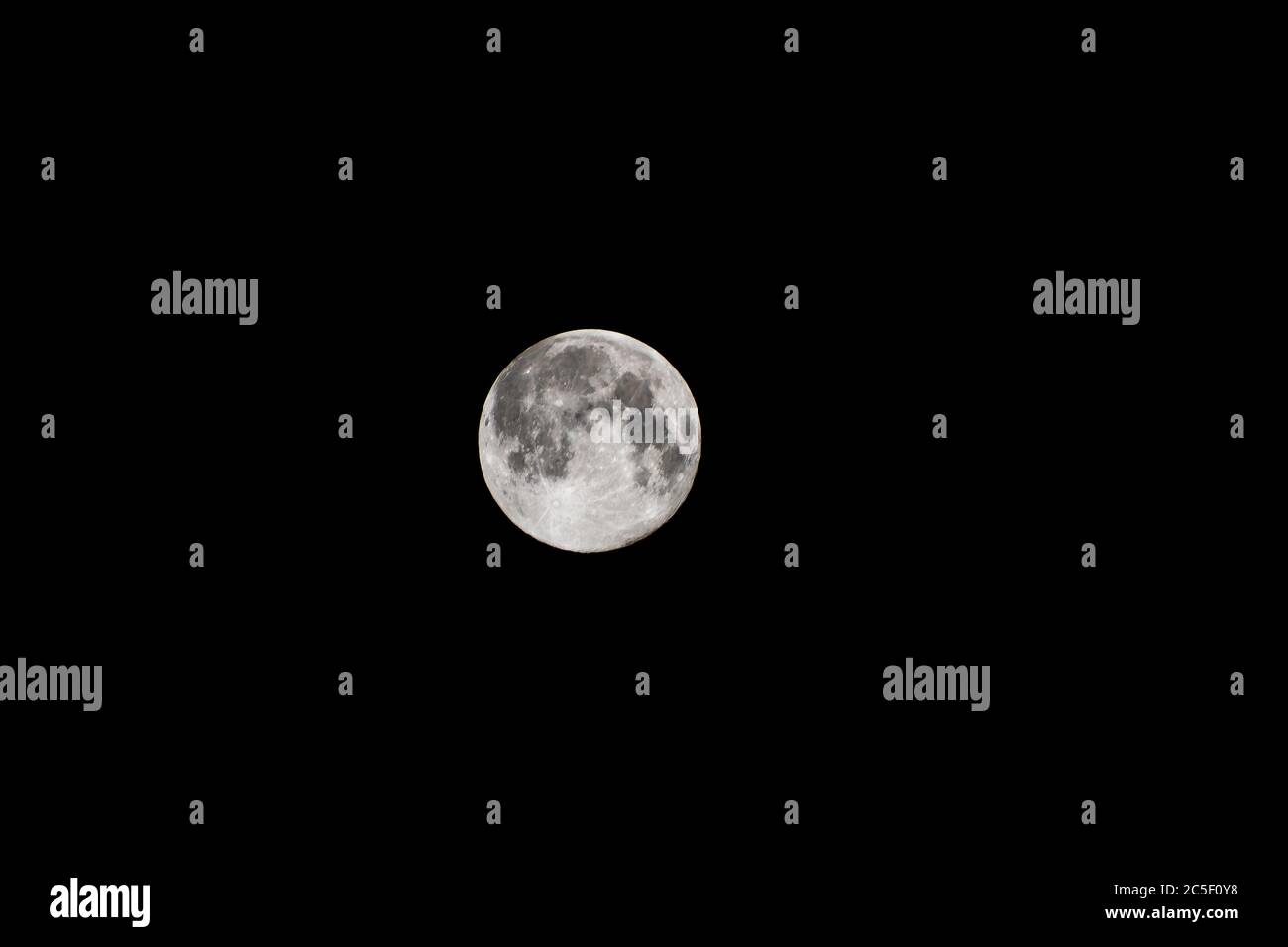 Ein heller Vollmond, der mitten in einer pechschwarzen Nacht hängt. Stockfoto