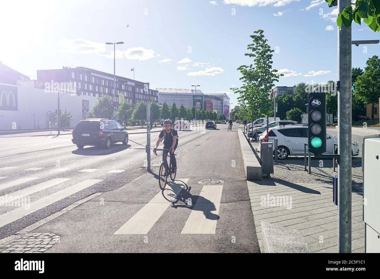 Helsinki / Finnland - 12. Juni 2018: Der Mann fährt auf dem Radweg mit dem Fahrrad. Grüne Ampel für Fahrrad ist an. Stockfoto
