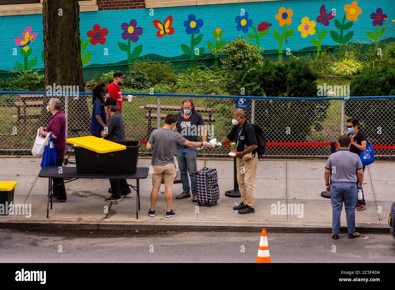 Menschen in Not stehen am Mittwoch, den 1. Juli 2020, im Sozialdienst Relief Bus im New Yorker Stadtteil Chelsea für Kleidung und Essen an. (© Richard B. Levine) Stockfoto