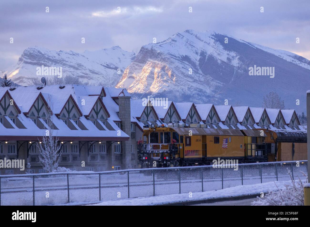 Sonnenaufgang auf dem Mount Lady MacDonald Mountain Peak Winter am frühen Morgen in Canmore Alberta FÄHRT EIN Loram Rail Grinder Train RG416 durch Stockfoto
