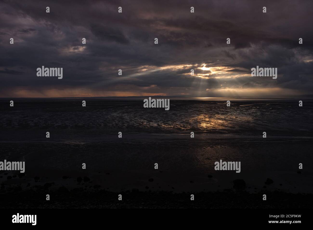 Vom schwarzen Himmel fallen Lichtwellen über den Strand der Morecambe Bucht bei Bolton Le Sands Stockfoto