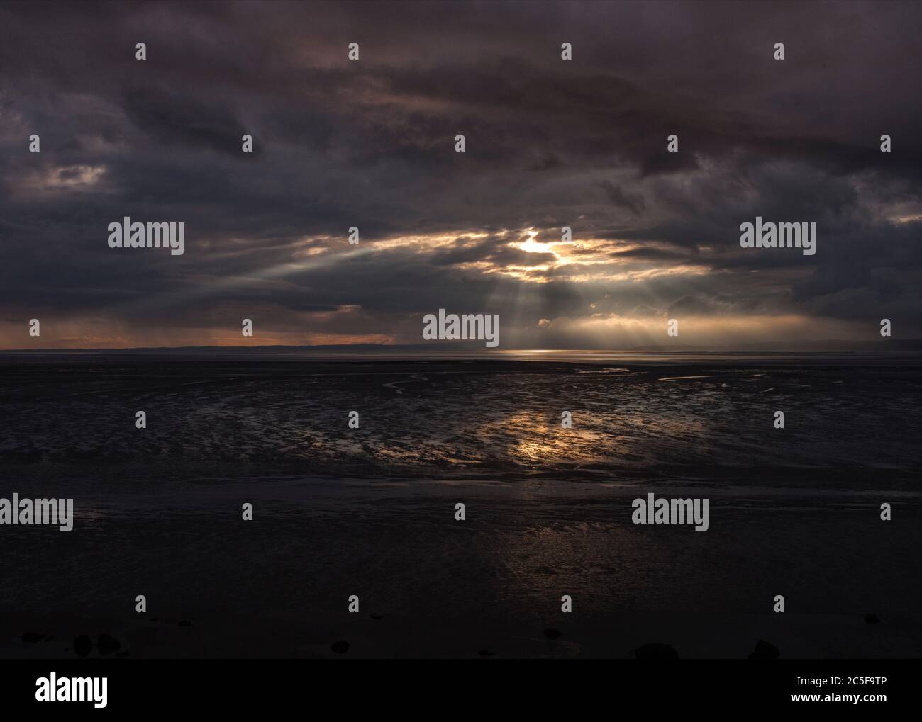 Vom schwarzen Himmel fallen Lichtwellen über den Strand der Morecambe Bucht bei Bolton Le Sands Stockfoto